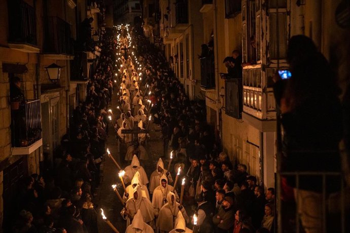 Archivo - Varios penitentes con antorchas participan en la procesión del Cristo de la Buena Muerte.