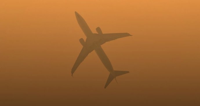 Un avión vuela en un cielo lleno de partículas en suspensión