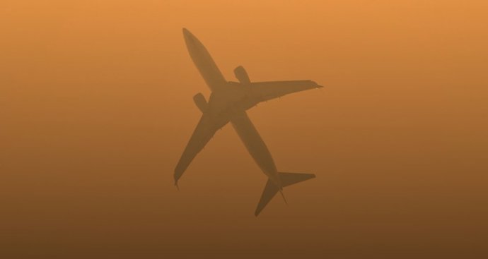 Um avião voa em um céu cheio de partículas suspensas no ar