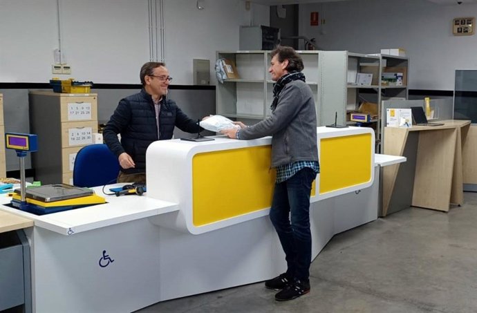 Archivo - Un usuario siendo atendido en una oficina de Correos Pay