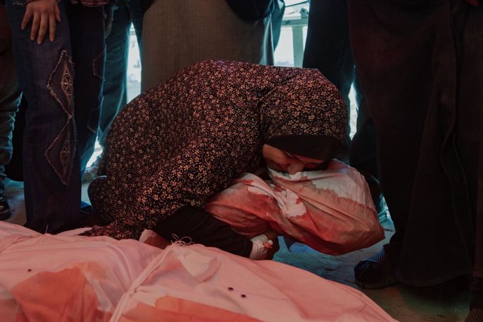 Uma mulher palestina abraça o corpo de uma criança morta em um bombardeio do exército israelense em Jabalia, no norte da Faixa de Gaza (arquivo).