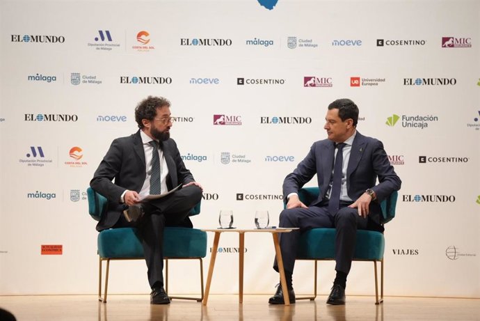 El presidente de la Junta de Andalucía, Juanma Moreno, conversa con el director de El Mundo, Joaquín Manso, en un foro informativo en Málaga.