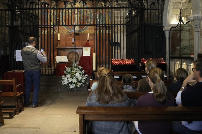 Un hombre fotografía un altar en honor al Papa Francisco con un centro de flores, en la capilla de Santa Lucía de Barcelona, a 21 de abril de 2025, en Barcelona, Cataluña (España). El Papa Francisco ha fallecido esta mañana, a las 7.35 horas, a la edad de