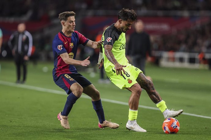 Antonio Sanchez, do RCD Mallorca, e Pablo Martin Gavira Gavi, do FC Barcelona, em ação durante a partida de futebol do Campeonato Espanhol, La Liga EA Sports, disputada entre FC Barcelona e RCD Mallorca no Estadi Olimpic Lluis Companys, em 22 de abril de 
