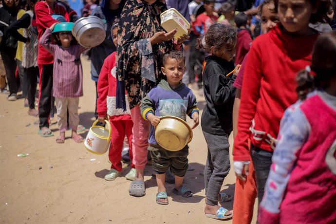 GAZA, 20 de abril de 2025 -- Crianças palestinas esperam para receber alimentos gratuitos de um centro de distribuição de alimentos na Cidade de Gaza, em 19 de abril de 2025. A Agência das Nações Unidas de Assistência aos Refugiados da Palestina no Orient