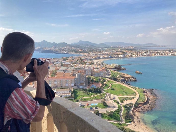 Archivo - Un turista fotografía una vista desde el faro de Cabo de Palos, en Cartagena (Murcia)