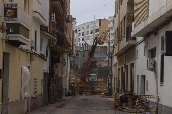 Archivo - Vecinos observan el derribo de viviendas con maquinaria pesada