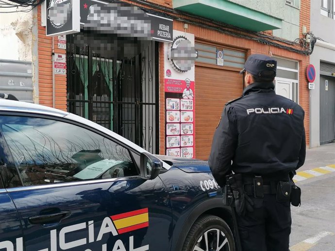 Un agente de la Policía Nacional junto a uno de los establecimientos inspeccionados