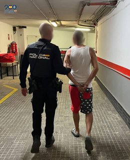 El fugitivo detenio, de espaldas, en dependencias policiales.