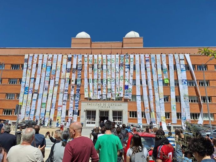 Decenas de alumnos y profesores despliegan un mural en la fachada de la facultad de Ciencias Físicas de la Universidad Complutense de Madrid para pedir una "inversión en calidad", el 23 de abril de 2025, en Madrid.