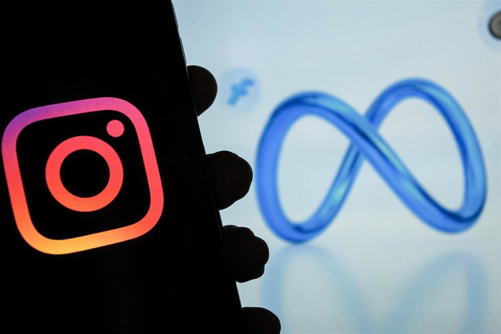 Archivo - Logo de Instagram en un smartphone con el logo de Meta al fondo