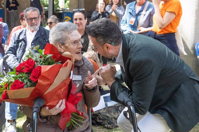 Una de las usuarias con un ramo de rosas por tener 100 años