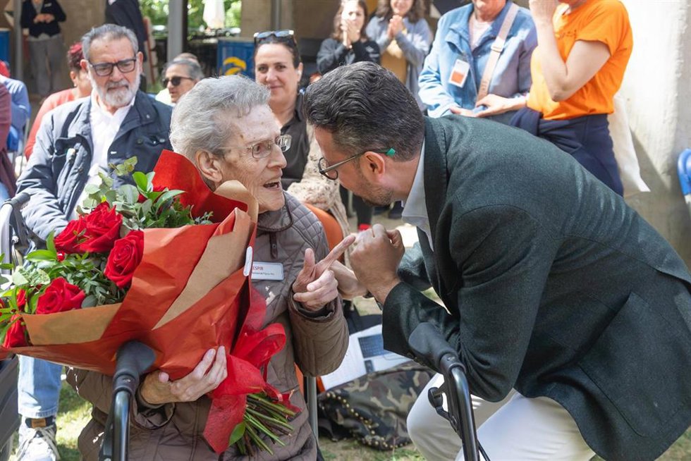 Una de las usuarias con un ramo de rosas por tener 100 años