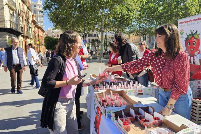 Reparto de tarrinas de fresas de Huelva por parte de UPA Andalucía en la Puerta de Jerez, en Sevilla.
