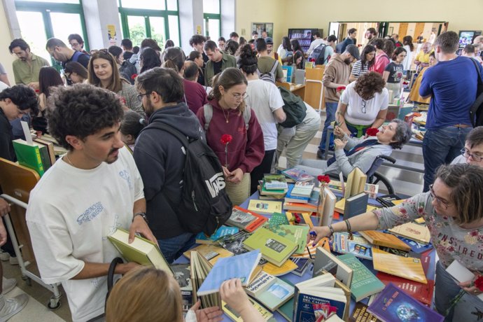 El hall de la Biblioteca Maimónides durante el reparto de libros y claveles.