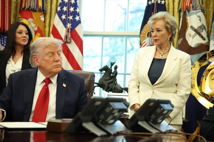 O presidente dos EUA, Donald Trump, assina ordens executivas no Salão Oval com a secretária de Educação, Linda McMahon.