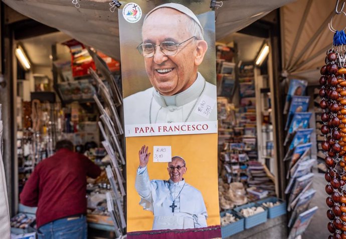 24 April 2025, Vatican, Vatican City: Pictures of the late Pope Francis are sold at a souvenir stand at St. Peter's Basilica. The Argentine pontiff, who led the Catholic Church from 2013, passed away on Easter Monday at the age of 88, leaving a lasting le
