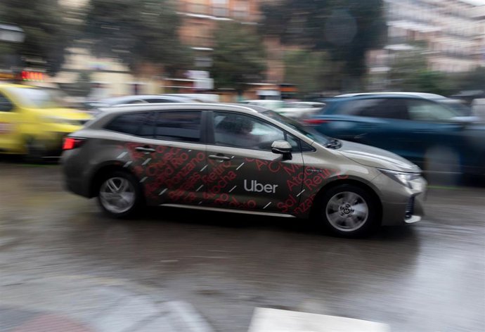 Archivo - Un vehículo con licencia VTC circula por una calle de Madrid