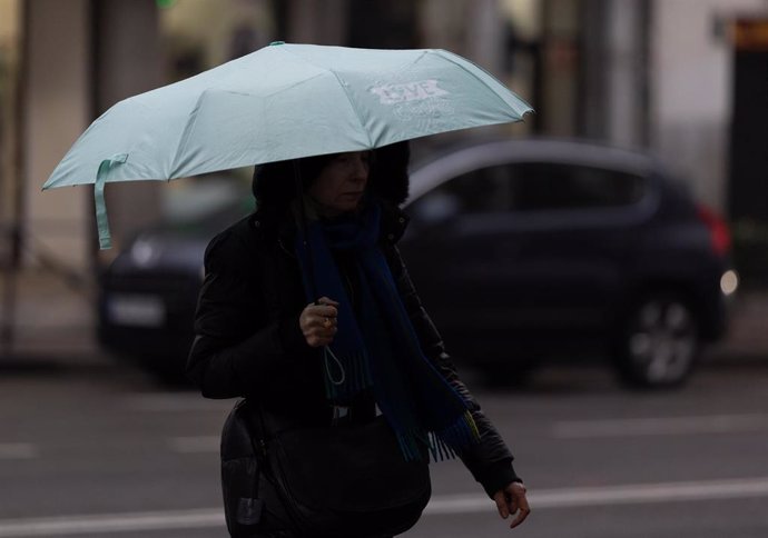 Archivo - Personas con paraguas bajo la lluvia 