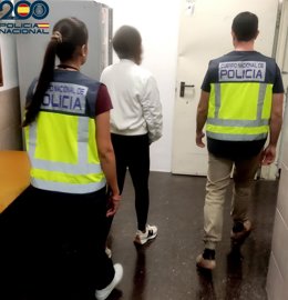 Una de las personas detenidas, conducida por agentes en dependencias policiales.