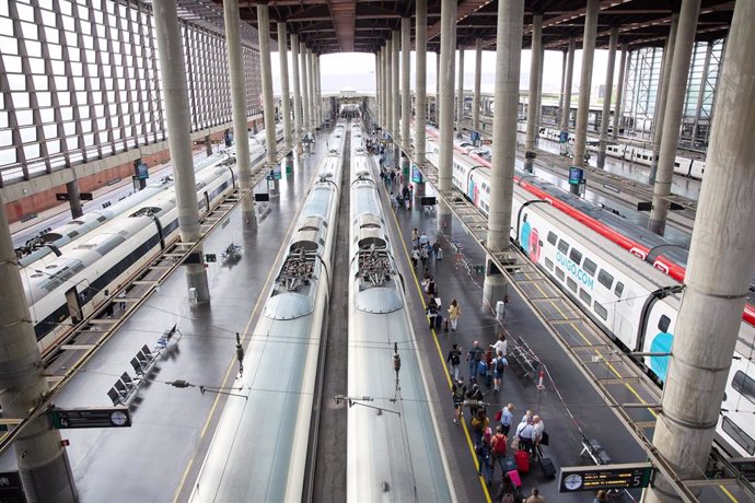 Archivo - Viajeros con maletas en uno de los andenes de la estación Almudena Grandes-Atocha