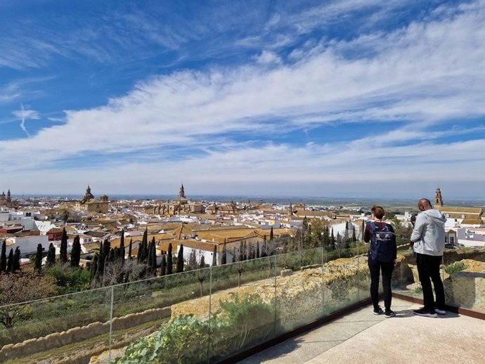 Archivo - Dos personas admiran el paisaje histórico urbano de Carmona desde un mirador
