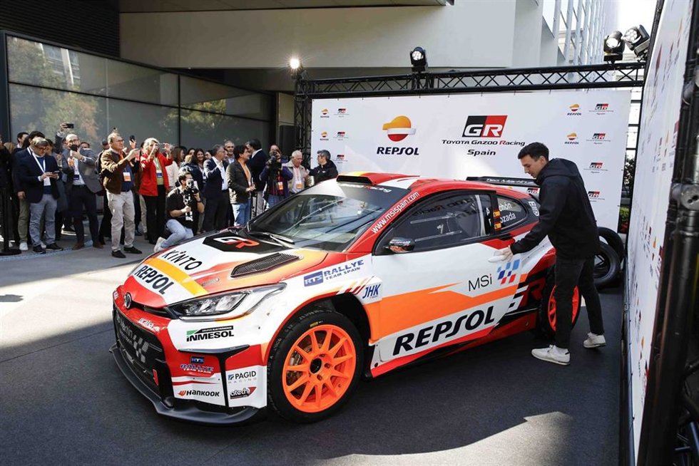 El piloto español de rallies Alejandro Cachón abre la puerta del Toyota GR Yaris Rally 2 con el competirá en WRC2.