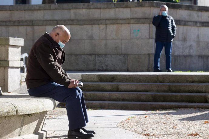 Archivo - Una persona lee en un banco el mismo día de la entrada en vigor de nuevas restricciones impuestas por la crisis del Covid-19 en el municipio de Vilalba, Lugo, (España), a 21 de noviembre de 2020. Entre las medidas, además del cierre perimetral, 