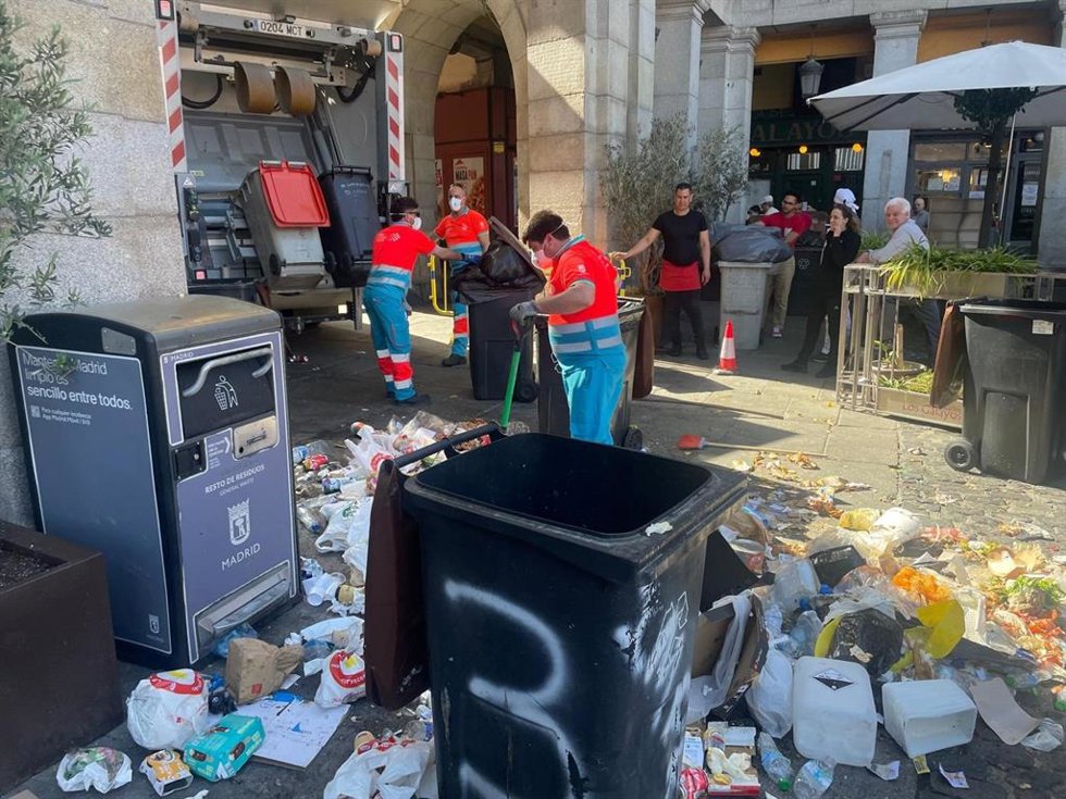 Operarios de limpieza recogen residuos en la Plaza Mayor en el cuarto día de huelga del servicio de basuras de Madrid