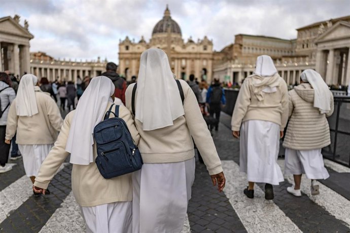 25 April 2025, Vatican, Vatican City: Nuns walk toward St. Peter's Basilica, where Pope Francis lies in an open coffin. 