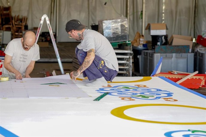 Archivo - Unos trabajadores, en una caseta del recinto ferial. 