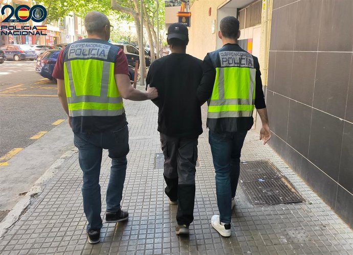 Agentes de la Policía Nacional con uno de los detenidos.