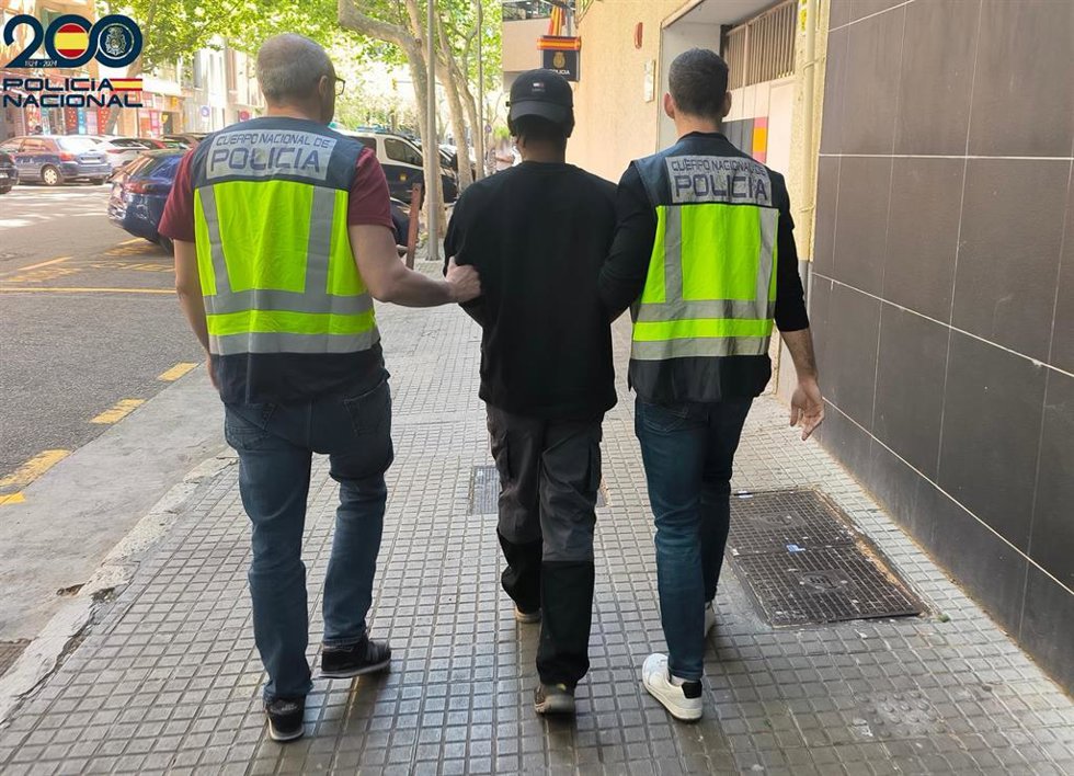Agentes de la Policía Nacional con uno de los detenidos.