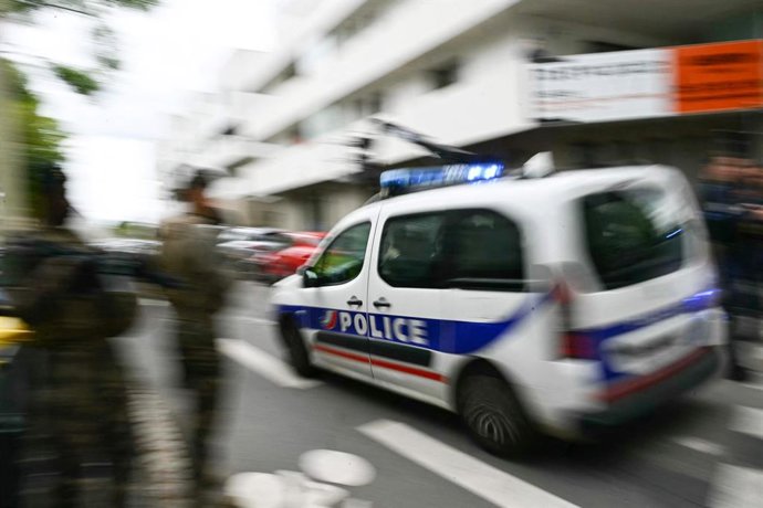 24 de abril de 2025, França, Nantes: Um carro de polícia dirige-se à escola secundária Notre-Dame de Toutes-Aides, onde um aluno foi morto e três outros ficaram feridos em um ataque com faca. Foto: Loic Venance/AFP/dpa