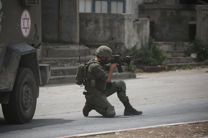 24 de abril de 2025, Nablus, Cisjordânia, Palestina: Um soldado israelense dispara contra uma casa palestina sitiada durante uma batida no campo de refugiados de Balata, a leste de Nablus, no norte da Cisjordânia, durante uma campanha de prisão. As forças