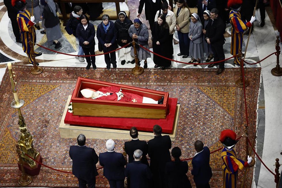 Algunos fieles contemplan los restos mortales del Papa Francisco, en la Basílica de San Pedro, en Roma (Italia).