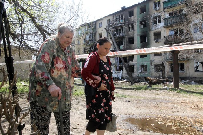 25 de abril de 2025, Pavlohrad, região de Dnipropetrovsk, Ucrânia: Duas mulheres idosas passam por um bloco de apartamentos incendiado, danificado pelo ataque maciço de drones russos, em Pavlohrad, região de Dnipropetrovsk, Ucrânia, em 25 de abril de 2025