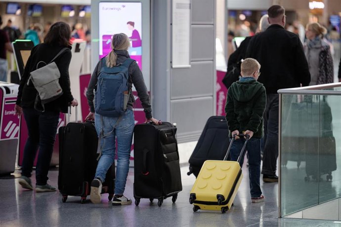 12 April 2025, North Rhine-Westphalia, Landesweit: Passengers walk through the departure in the departure hall at Duesseldorf Airport as pupils in North Rhine-Westphalia begin their Easter break on Friday lunchtime. 