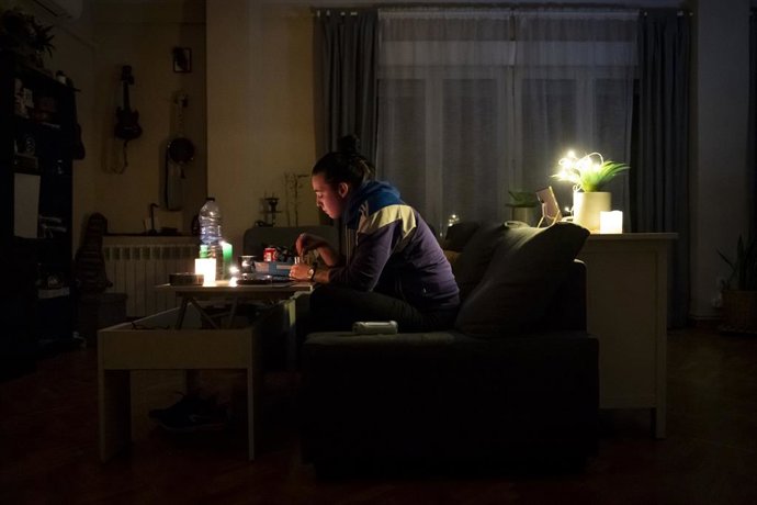 Una mujer se ilumina en el interior de su casa con la ayuda de velas e iluminación a pilas durante el apagón general, en Madrid, a 28 de abril de 2025. Un apagón eléctrico ha asolado España, Portugal y parte de Francia a las 12.30h. de la mañana. Sin sabe