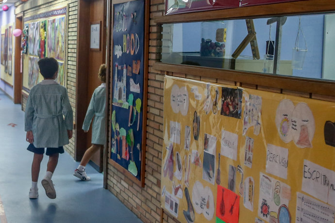 Imagen de archivo de dos niños entrando en una clase del colegio.