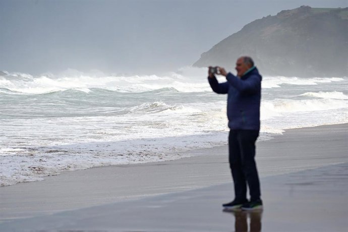 Archivo - Un hombre toma fotos del oleaje, en una imagen de archivo.