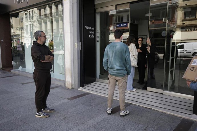 La dependienta de un comercio de León informa a cliente del cierre por el apagón.