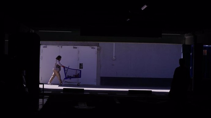 Una mujer sale del supermercado en A Coruña durante el apagón, a 28 de abril de 2025, en A Coruña, Galicia.