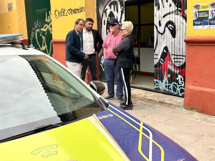 Ismael Sánchez, con representantes de la asociación Mácula Retina, con un patrullero de la Policía Local en un primer plano.