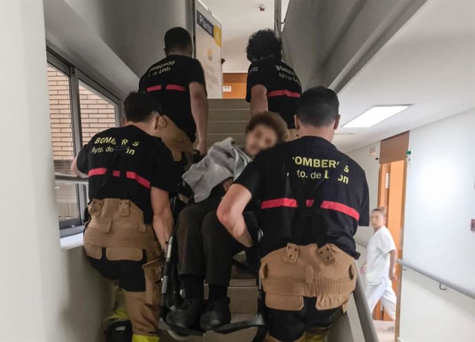 Los Bomberos de León trasladan a una persona con movilidad reducida durante el apagón eléctrico.