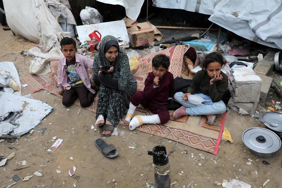 Una familia de palestinos desplazados cerca de su tienda de campaña, destruida por un bombardeo del Ejército de Israel contra el centro de la Franja de Gaza (archivo)