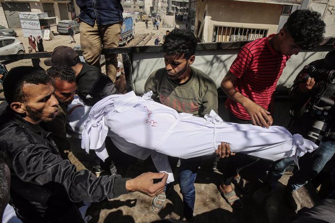 Palestinos con el cadáver de una persona muerta a causa de un bombardeo ejecutado por el Ejército de Israel contra la Franja de Gaza (archivo)