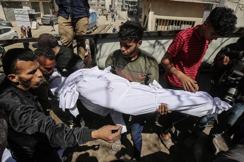 Palestinos con el cadáver de una persona muerta a causa de un bombardeo ejecutado por el Ejército de Israel contra la Franja de Gaza (archivo)