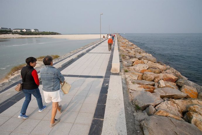 Archivo - Varias personas pasean durante la pleamar en el espigón de Foz, junto a la playa de A Rapadoira, a 19 de septiembre de 2024, en Lugo, Galicia (España). Galicia está hoy, 19 de septiembre, en aviso por las mareas vivas, que son las mareas que se 