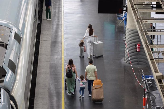 Archivo - Viajeros con maletas en uno de los andenes de la estación Almudena Grandes-Atocha.